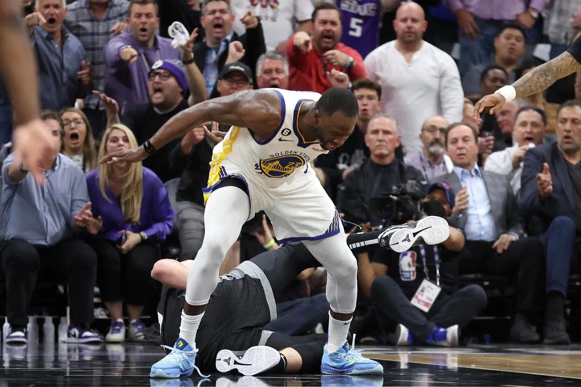 Draymond Green of the Golden State Warriors steps over Domantas Sabonis of the Sacramento Kings in the second half during Game 2 of their NBA play-offs.