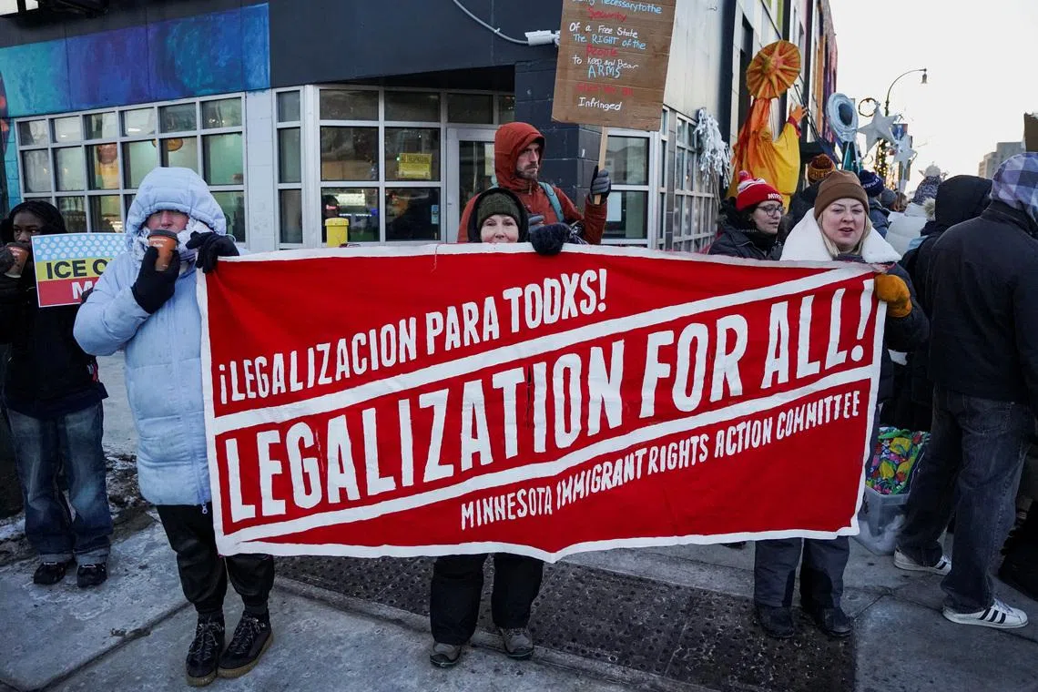 People hold a banner during a demonstration against the presence of federal immigration agents in Minneapolis, Minnesota, U.S., January 28, 2026. REUTERS/Seth Herald