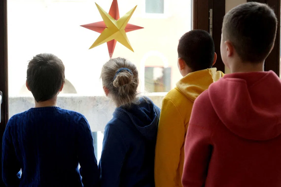 FILE PHOTO: Children look from the window at a nursery in Venice, Italy February 18, 2025. REUTERS/Manuel Silvestri/File Photo