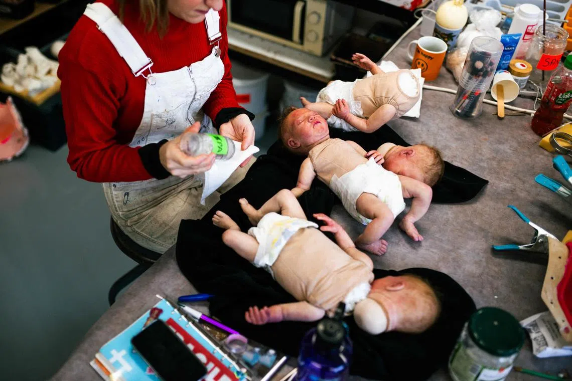 An employee cleans fake babies made for cinema and television created by Cinebebe (Cinebaby), a specialised brand of the Studio Junon -a company creating visual effects- in Saint-Denis, suburbs of Paris, on January 21, 2025. (Photo by Julie SEBADELHA / AFP)