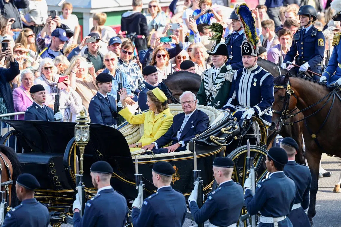 A cortege with King Carl XVI Gustaf and Queen Silvia passes through the crowd in central Stockholm, marking the King's 50th anniversary celebrations.