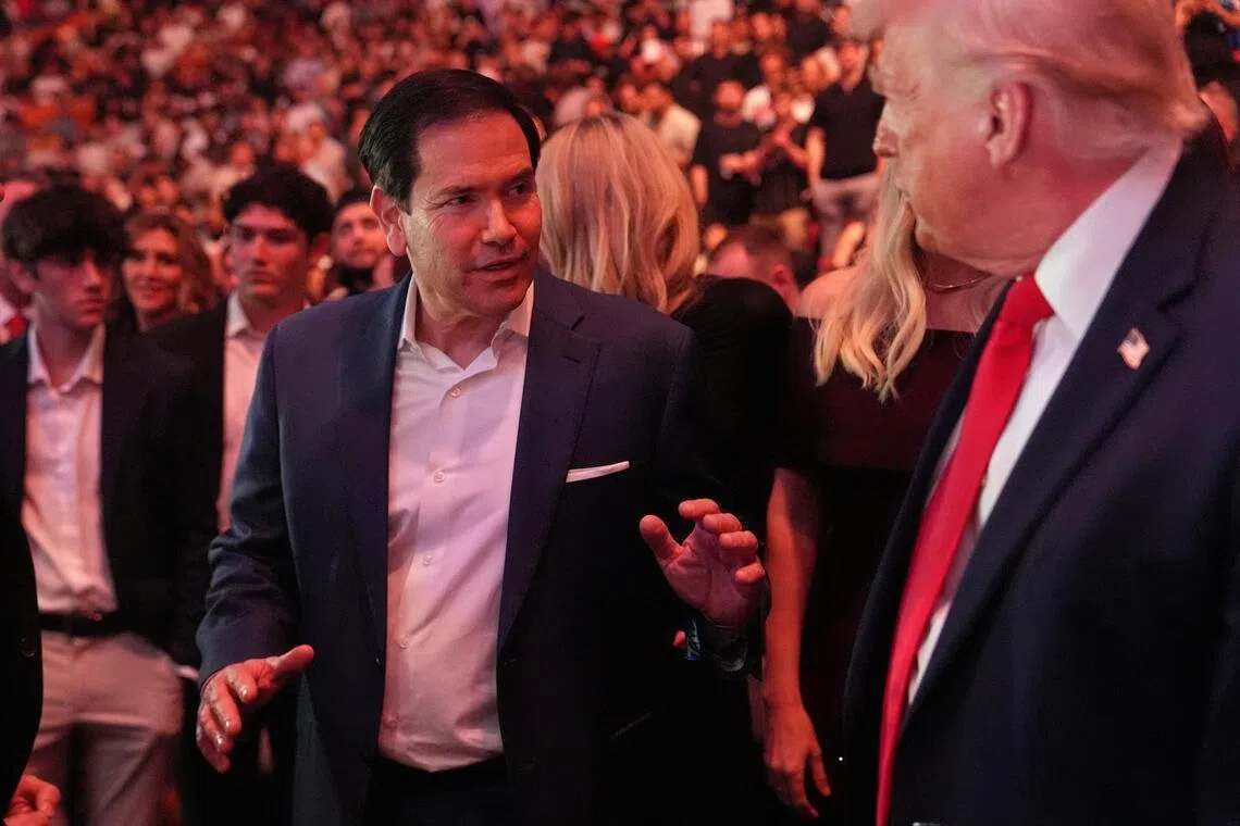 US President Donald Trump talks to  Secretary of State Marco Rubio while attending UFC 327 at Kaseya Center in Miami on April 11, 2026.