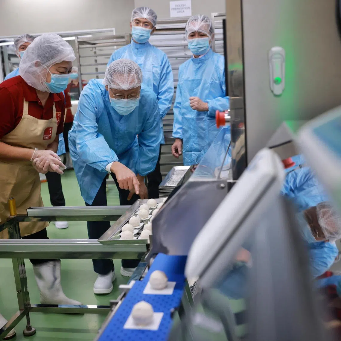 Minister for Manpower Tan See Leng viewing an automated pau machine at Sin Mui Heng Food Industries on Dec 14, 2022.