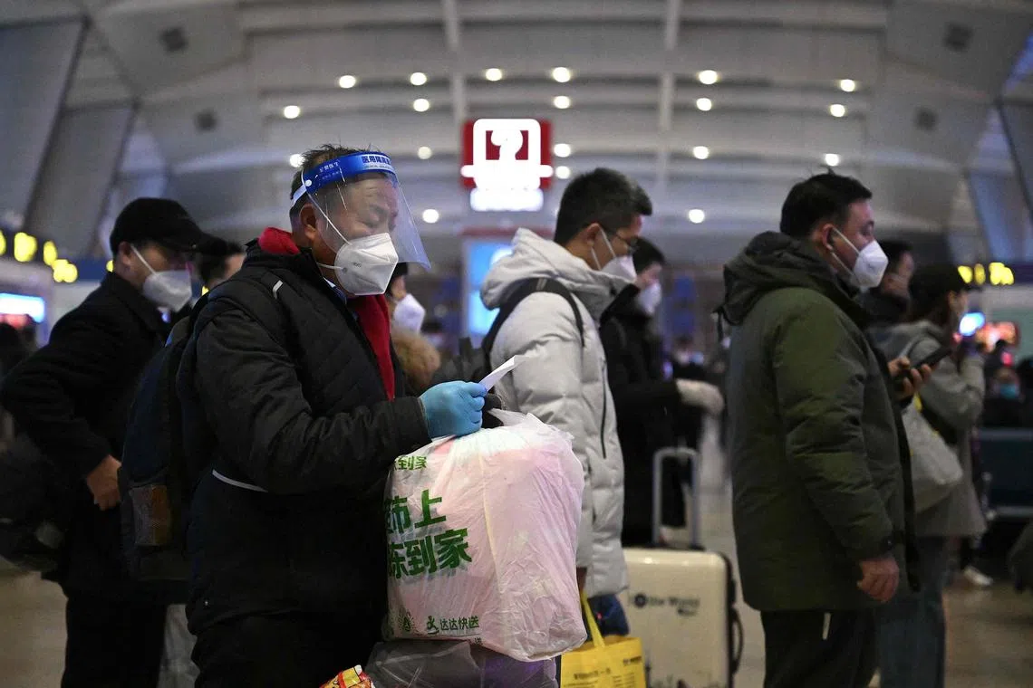 Passengers queue at a train station in Beijing on Jan 5, 2023.