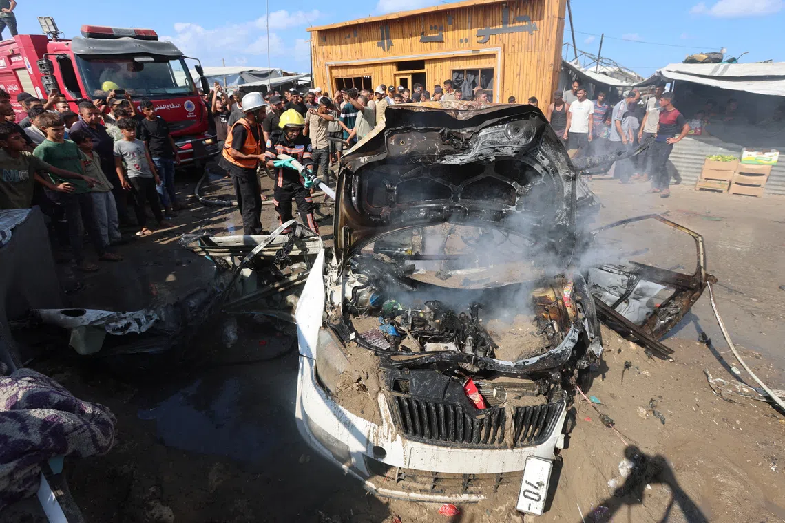 Palestinian firefighters extinguishing a fire on a vehicle hit by an Israeli air strike in Khan Younis, in the southern Gaza Strip, on Sept 23.