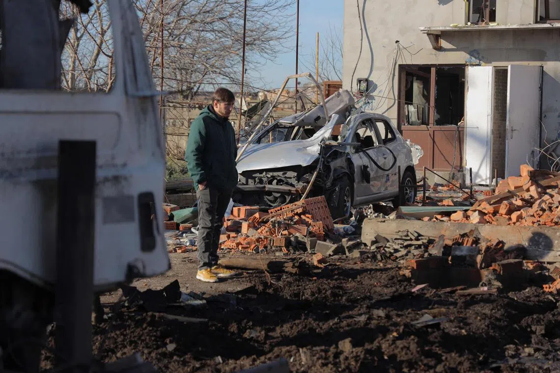 A local resident standing in front of a damaged car and house in Odesa, southern Ukraine, after a massive drone and missile attack by Russia, on March 7.