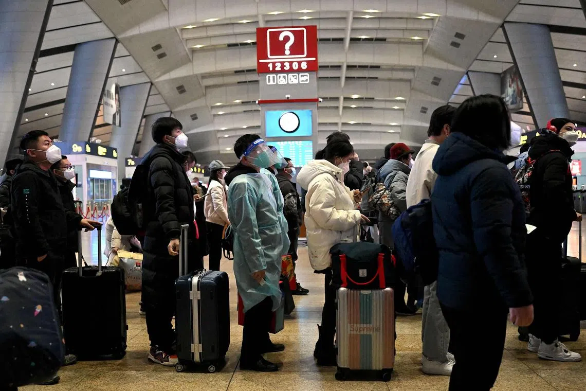 Passengers queue at a train station in Beijing on Jan 5, 2023.
