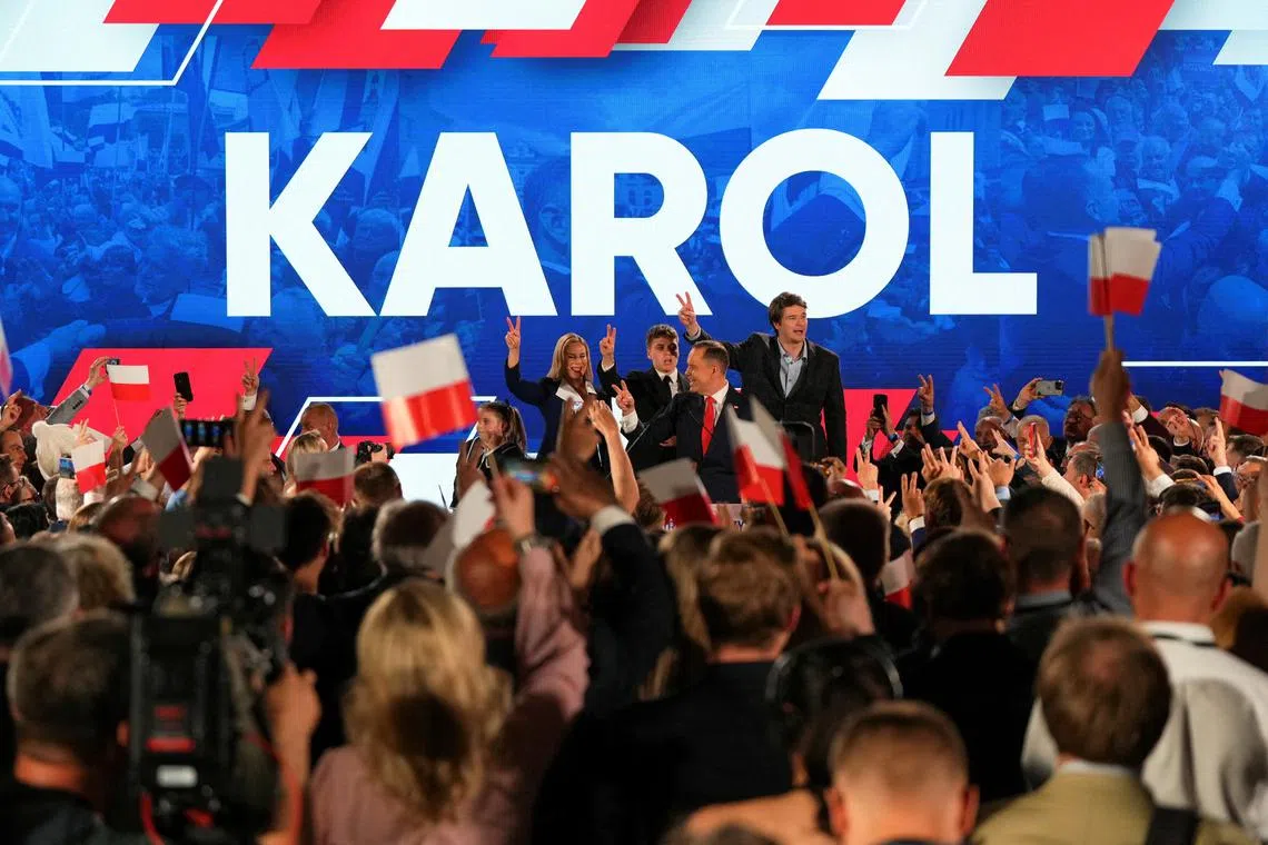 FILE PHOTO: Polish presidential candidate Karol Nawrocki, backed by the main opposition Law and Justice (PiS) party, gestures next to his wife Marta Nawrocka, his sons Antoni and Daniel and daughter Katarzyna, as they react to the exit polls of the second round of the presidential election, in Warsaw, Poland, June 1, 2025. REUTERS/Aleksandra Szmigiel/File Photo