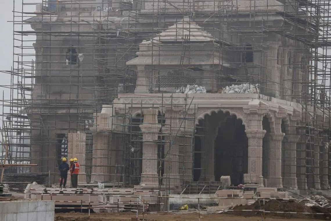 Workers stand in front of the under construction site of the Hindu Ram Temple in Ayodhya, India, December 29, 2023. REUTERS/Anushree Fadnavis