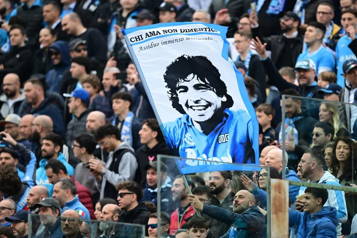 Soccer Football - Serie A - Parma v Napoli - Stadio Ennio Tardini, Parma, Italy - April 12, 2026 Napoli fans in the stands hold up a sign of Diego Maradona in the stands before the match REUTERS/Daniele Mascolo