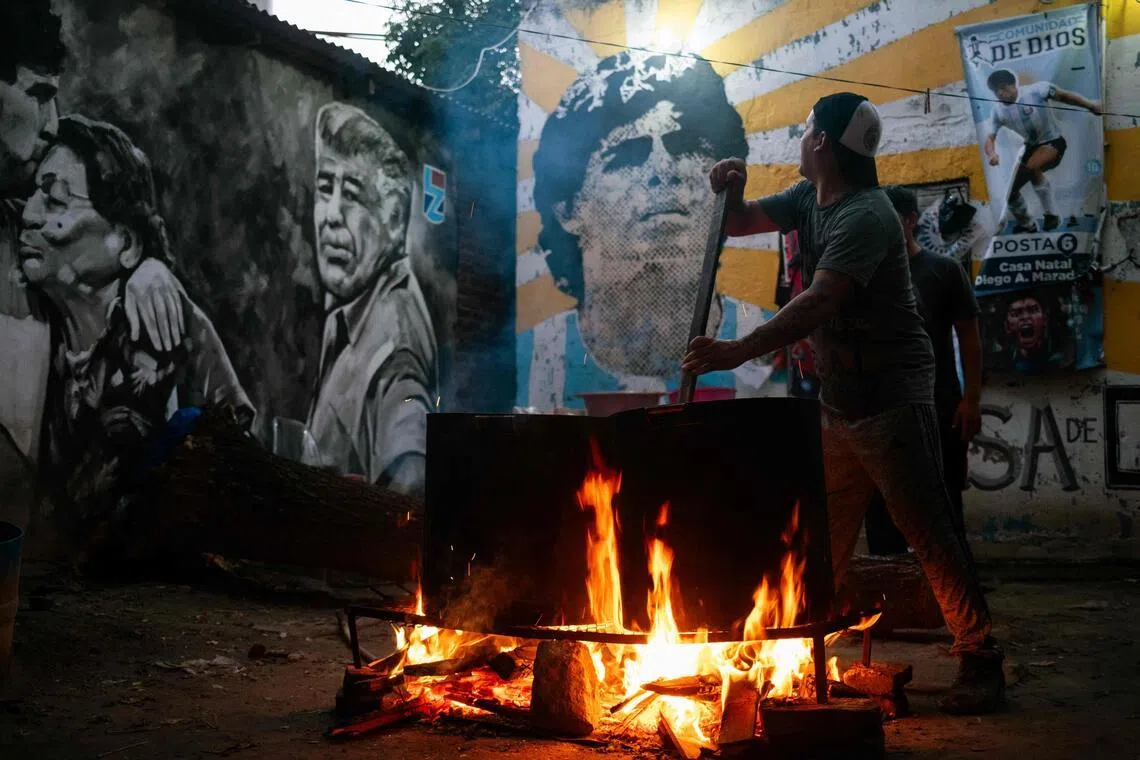 A volunteer prepares a stew for neighbours in need at the yard of the childhood home of the late football star Diego Maradona, now transformed into a soup kitchen on April 9, 2026.