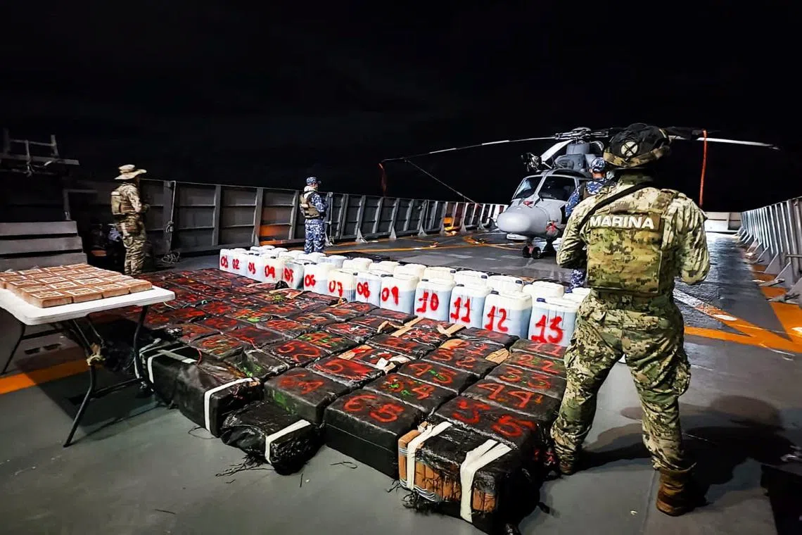 Members of the Mexican Navy stand guard next to packages on display after seizing some 8.4 thousand kilograms of illicit cargo and arresting 23 people in an operation off the country's southwestern Pacific coast, near Lazaro Cardenas, Michoacan, Mexico, in this undated handout photo released on October 18, 2024.  Mexican Navy/Handout via REUTERS