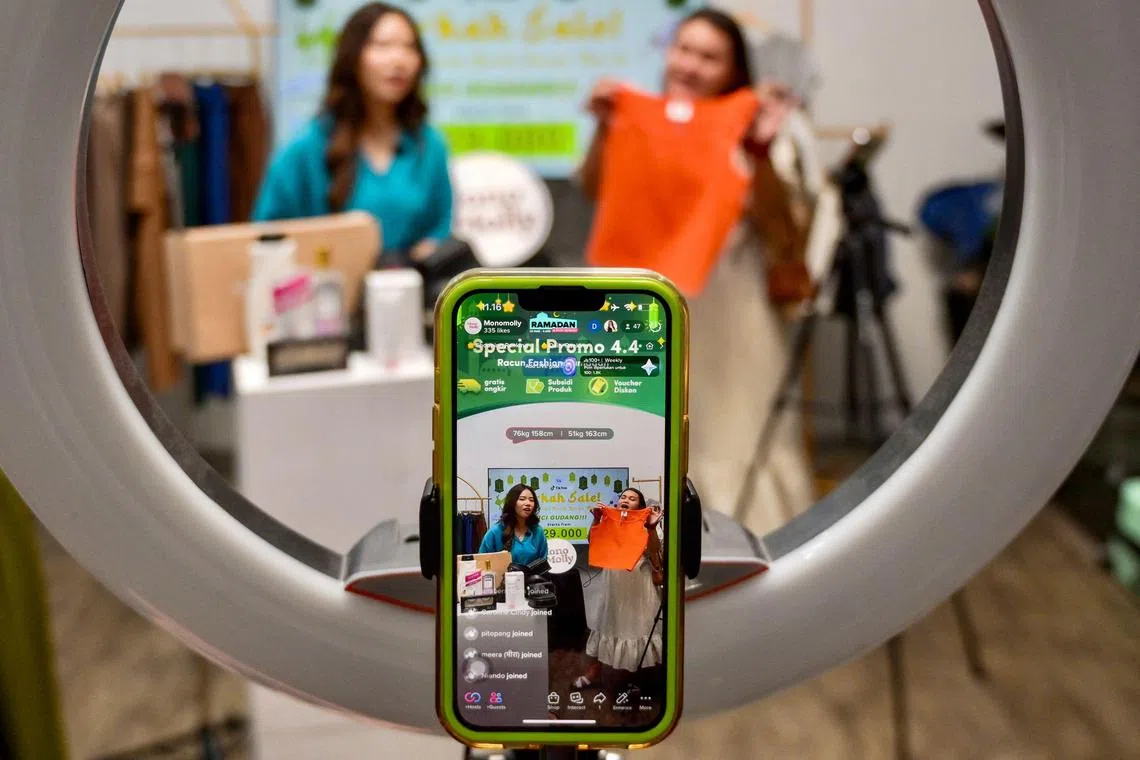 Employees working for a TikTok channel offering merchandise for sale through a TikTok livestream in a room in Jakarta. 