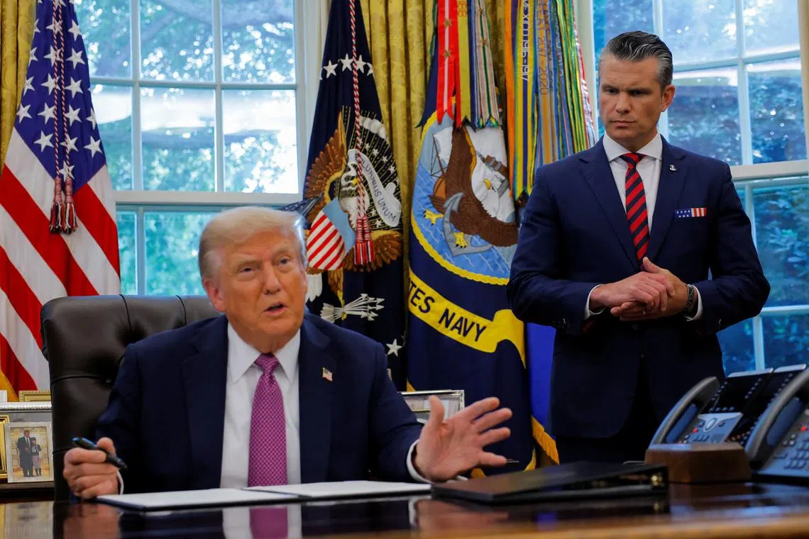 U.S. Defense Secretary Pete Hegseth listens as U.S. President Donald Trump speaks with the media while signing an executive order in the Oval Office, at the White House in Washington, D.C., U.S., September 5, 2025. REUTERS/Brian Snyder