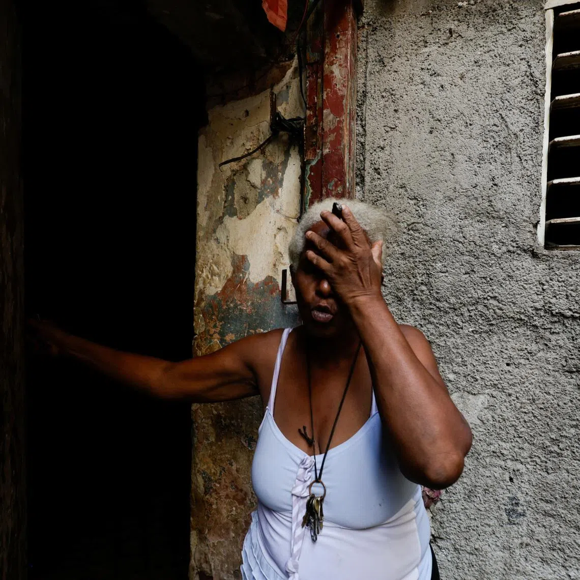 Felicia de la Caridad Alvarez reacts the moment power went out, as Cuba's state-run economy has descended into a full-blown crisis.