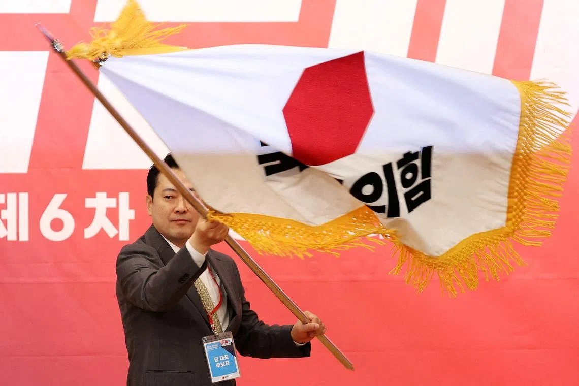 Jang Dong-hyeok, the newly elected leader of the main opposition People Power Party waves party's flag during the final round of its convention in Seoul, South Korea, August 26, 2025.   REUTERS/Kim Hong-Ji
