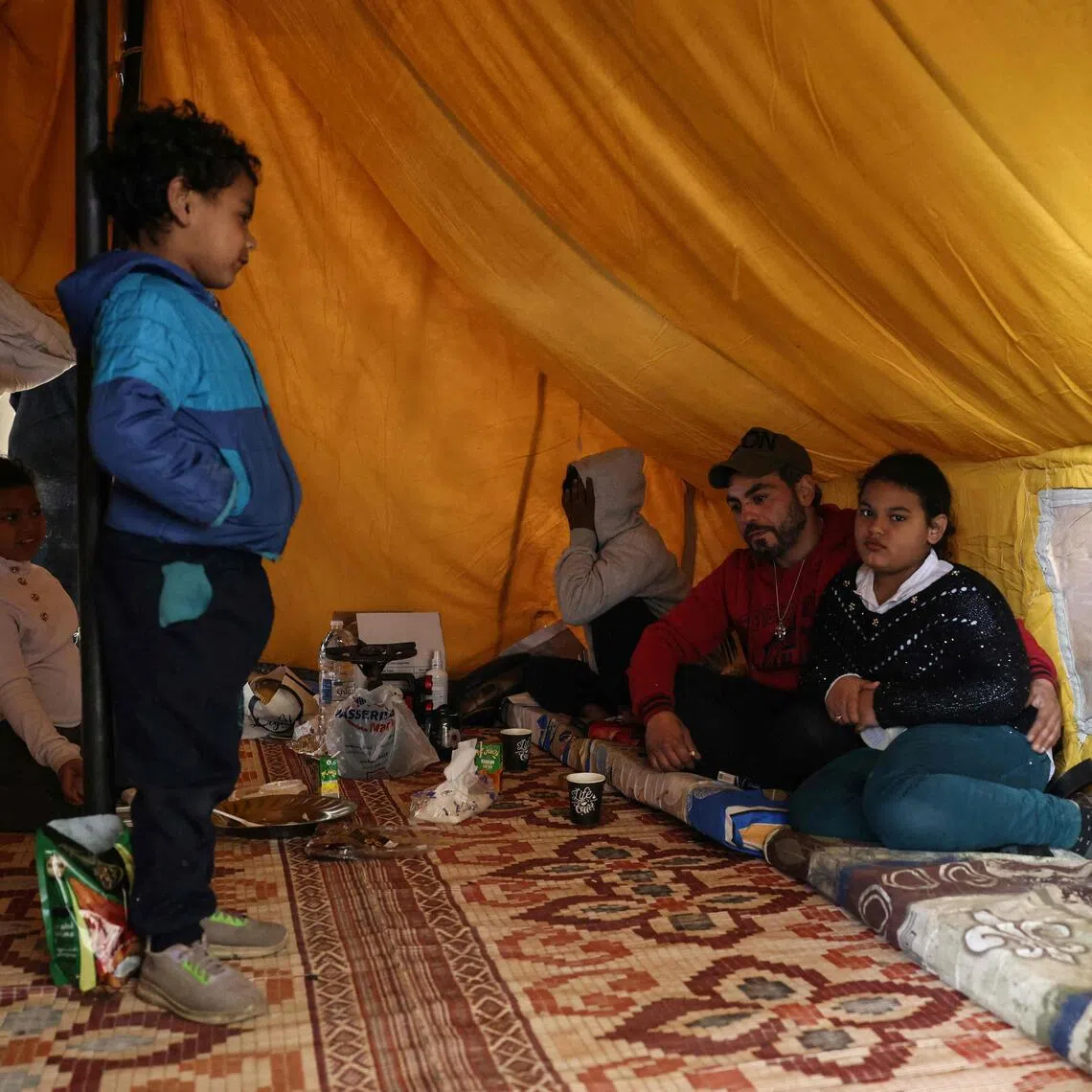 A displaced family sits inside their tent at a sports stadium in Beirut that was converted into a shelter.