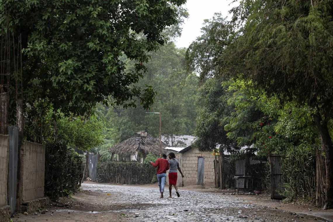 Women walk under the rain in the Malfety neighborhood of Fort Liberte, Haiti April 27, 2024. REUTERS/Ricardo Arduengo