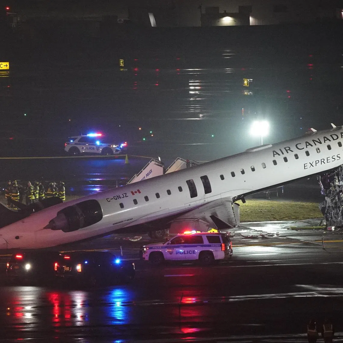 Emergency crews work around an Air Canada Express jet that had collided with a ground vehicle at New York's La Guardia Airport in Queens, New York, U.S. March 23, 2026.  REUTERS/Bing Guan