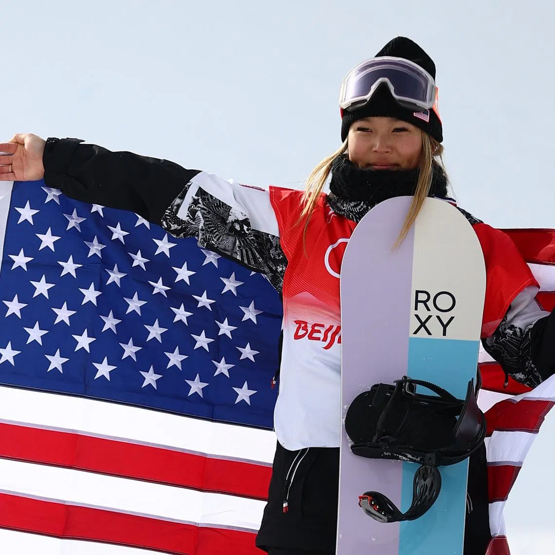 FILE PHOTO: 2022 Beijing Olympics - Snowboard - Women's Snowboard Halfpipe Final Run 3 - Genting Snow Park, Zhangjiakou, China - February 10, 2022. Gold medallist Chloe Kim of the United States celebrates during the flower ceremony. REUTERS/Lisi Niesner/File Photo