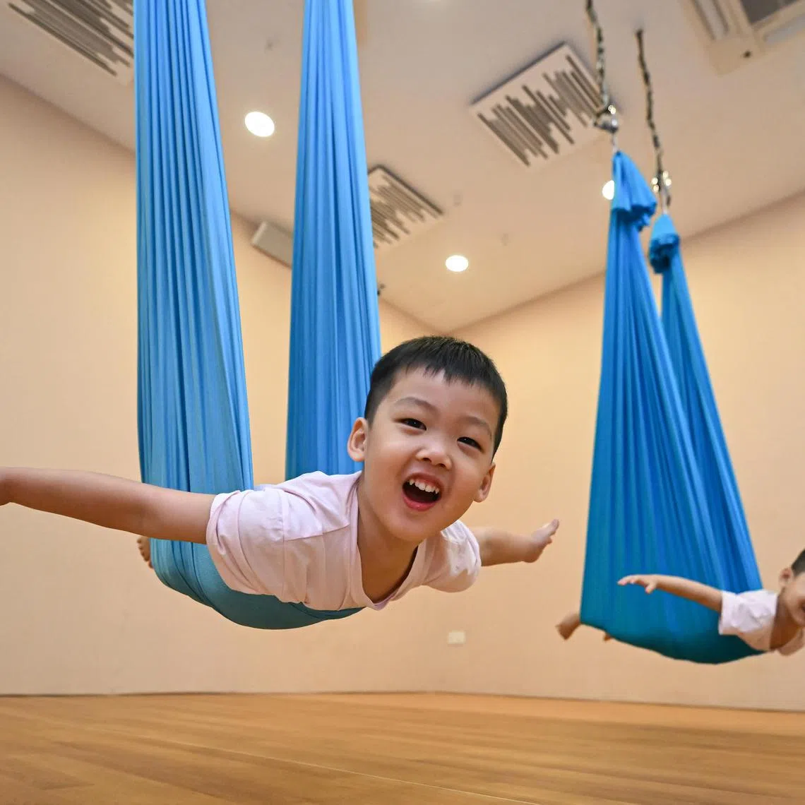 (From left) Twins Axel and Lloyd Tan, both three, during an aerial yoga class at Mindful Space on June 24, 2023.