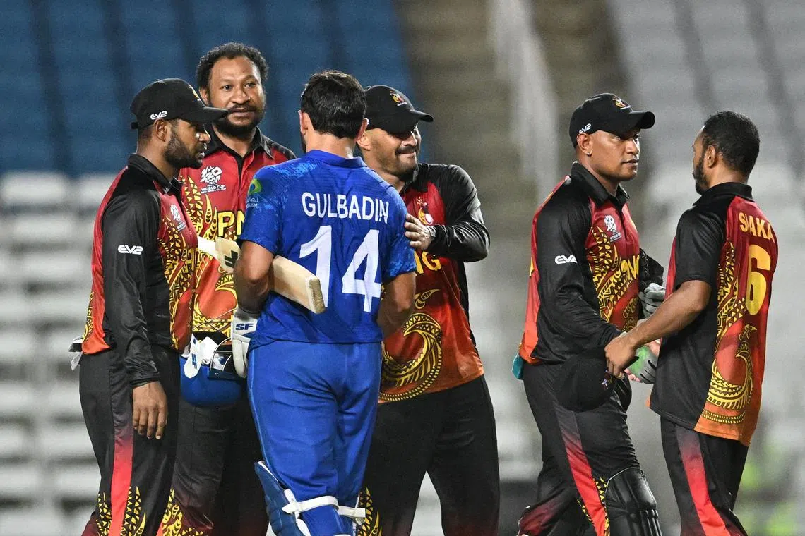 Papua New Guinea players congratulating Gulbadin Naib after he hit a six for Afghanistan to win the Twenty20 World Cup group C match at Brian Lara Cricket Academy Stadium in Tarouba, Trinidad and Tobago on June 13, 2024.