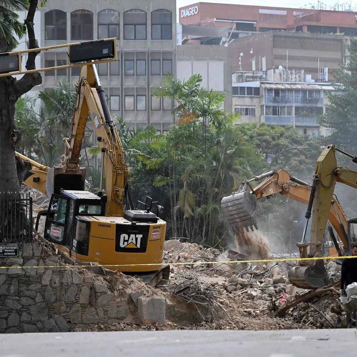 Heavy machinery removes debris from a collapsed building at the Chacao municipality in Caracas, on July 6.
