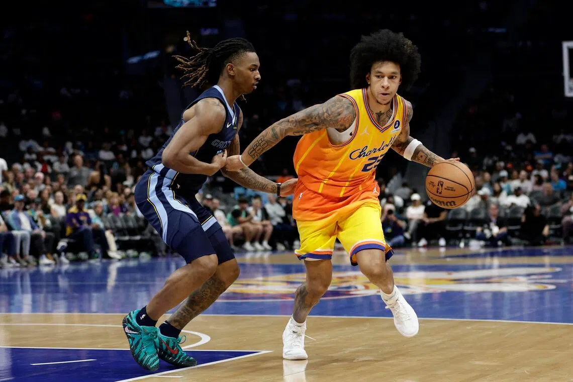 Charlotte Hornets guard Tre Mann keeps the ball away from Memphis Grizzlies guard Javon Small during the fourth quarter at Spectrum Center. 