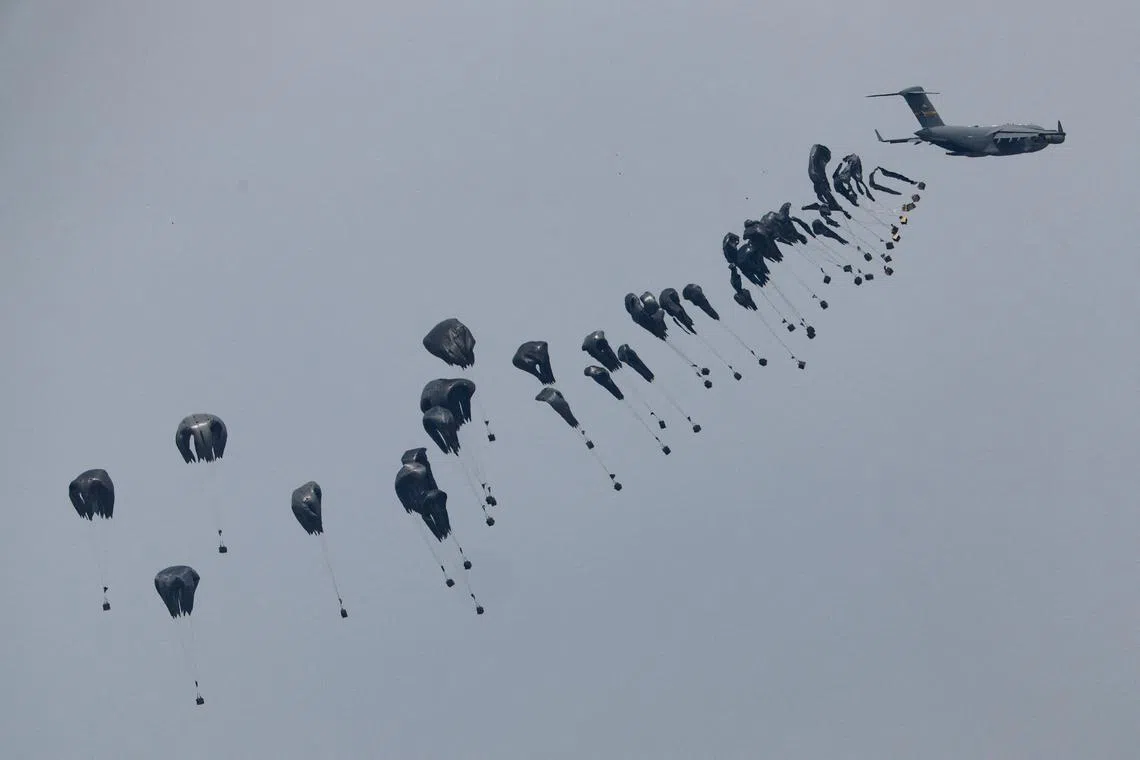 Humanitarian aid falling through the sky towards the Gaza Strip after being dropped from an aircraft, amid the ongoing conflict between Israel and the Palestinian Islamist group Hamas, as seen from Israel's border with Gaza, in southern Israel onMarch 17, 2024. 