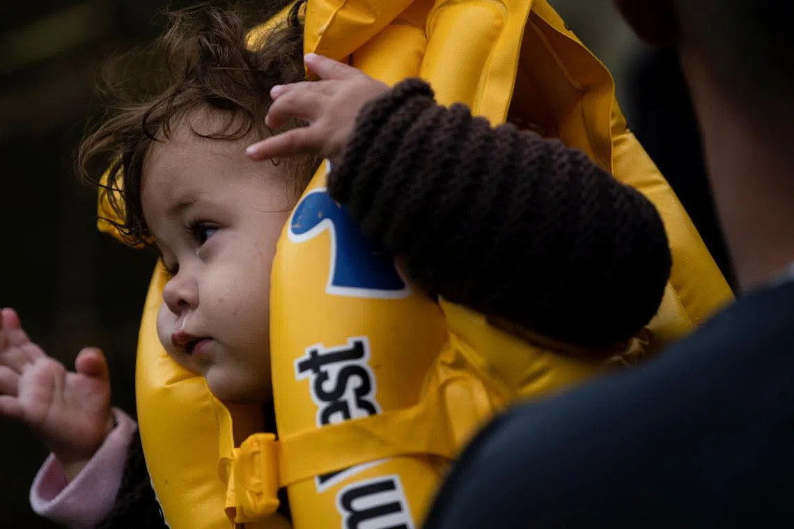 A migrant child wears a life vest while getting ready to cross the Rio Grande river, from Mexico into the US, in December 2022.