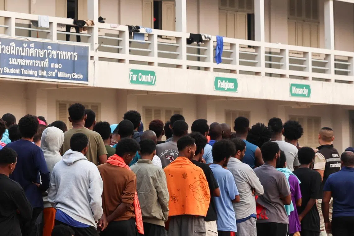 Multinational victims of scam centres, who were trafficked into working in Myanmar and were sent to Thailand on February 12 amid a mounting crackdown on scam centres operating along a porous border, queue to get food at a shelter inside the 310th Military District (Fort Wachiraprakan), as they wait for their embassies to pick them up, in Tak province, Thailand February 19, 2025. REUTERS/Chalinee Thirasupa