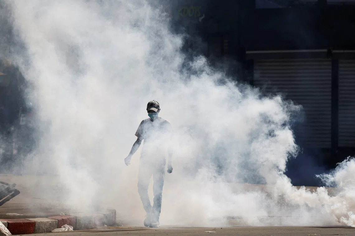 A man walking through tear gas fired by police officers during a nationwide youth-led demonstration over frequent power outages and water shortages, in Antananarivo, Madagascar, on Oct 9, 2025. 