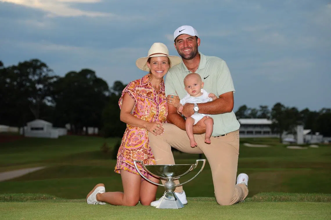 Scottie Scheffler of the United States celebrating with his wife Meredith, son Bennett and the FedExCup trophy after winning the FedExCup and the Tour Championship.