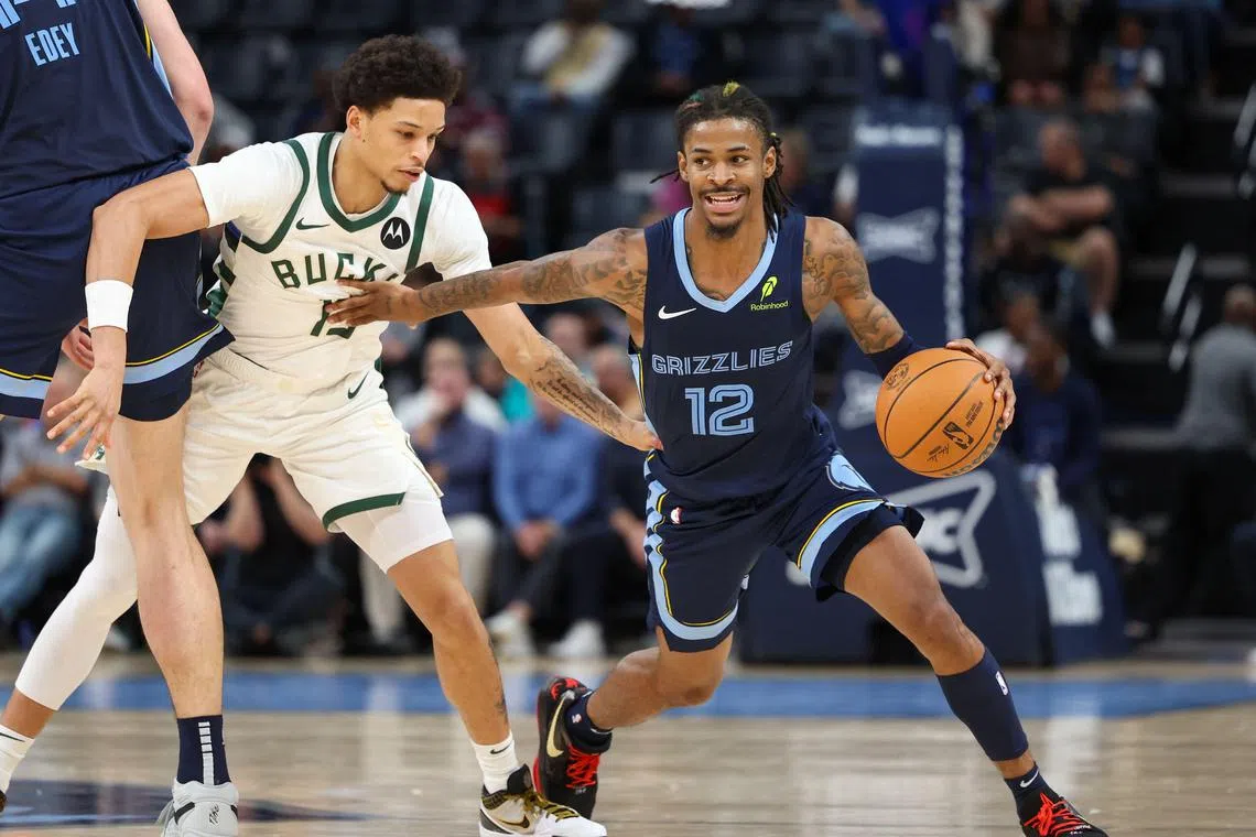 Ja Morant of the Memphis Grizzlies dribbles the ball against Ryan Rollins of the Milwaukee Bucks during the fourth quarter at FedExForum.