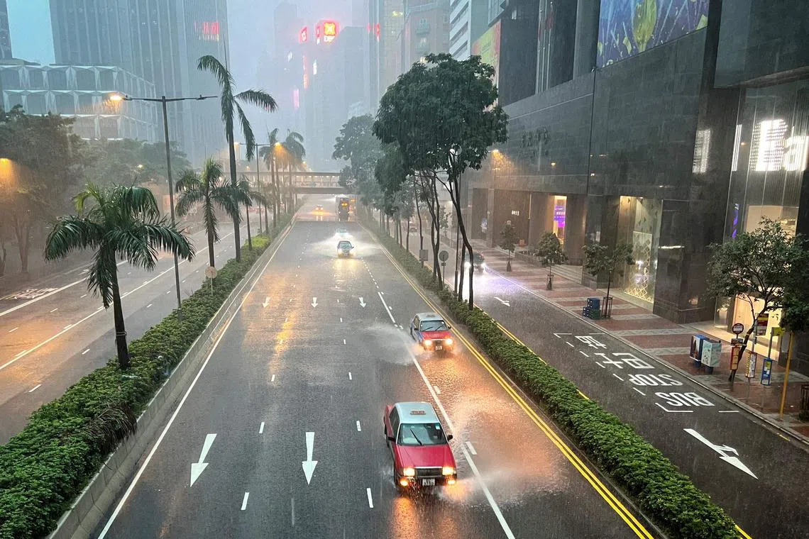 Taxis and other vehicles drive along a waterlogged Gloucester Road in Hong Kong's Wanchai district, on Aug 5.