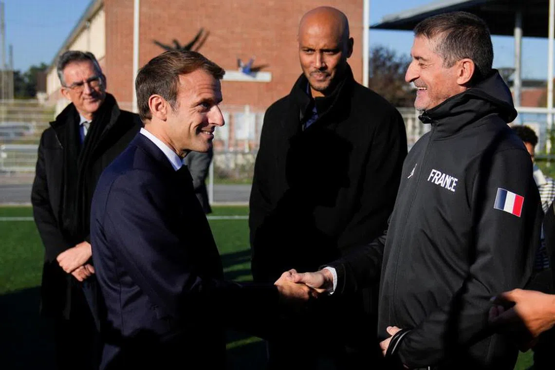 French President Emmanuel Macron shakes hands with head of the French Basketball Federation Jean-Pierre Siutat at a stadium ahead of the 2024 Olympic Games, in Tremblay-en-France, outside Paris, October 14, 2021. Francois Mori/Pool via REUTERS/File Photo