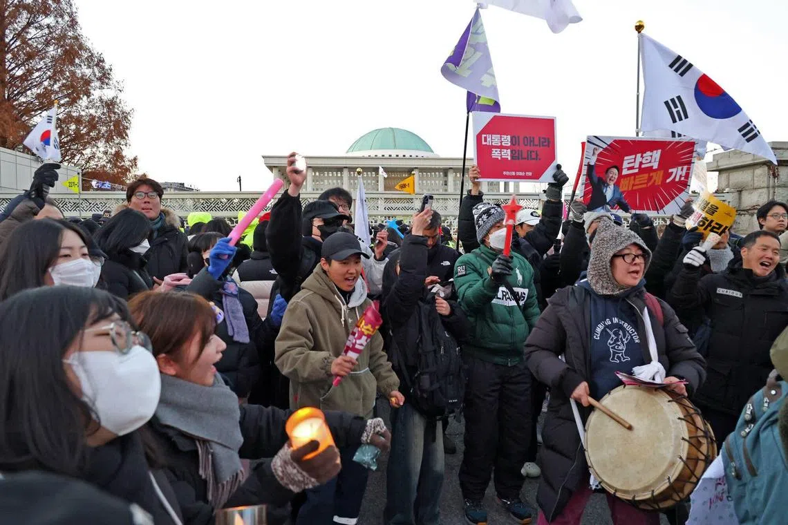 Demonstrators reacting after lawmakers passed a motion to impeach South Korean President Yoon Suk Yeol during a protest outside the National Assembly in Seoul on Dec 14. 