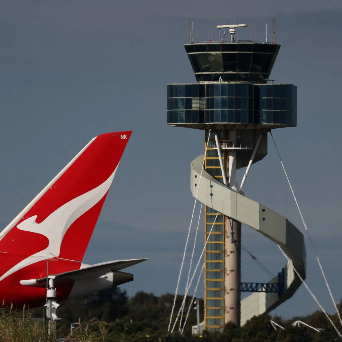 A Qantas plane passes an air traffic control tower as it taxis along a runway Sydney Airport, in Sydney, Australia, August 21, 2026.  REUTERS/Hollie Adams