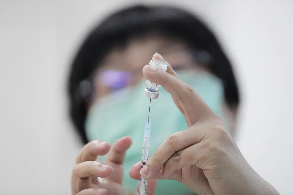 A healthcare assistant from Ren Ci @ Batok Street 52 preparing the Pfizer-BioNtech Covid-19 vaccine, 11 Jan 2021.