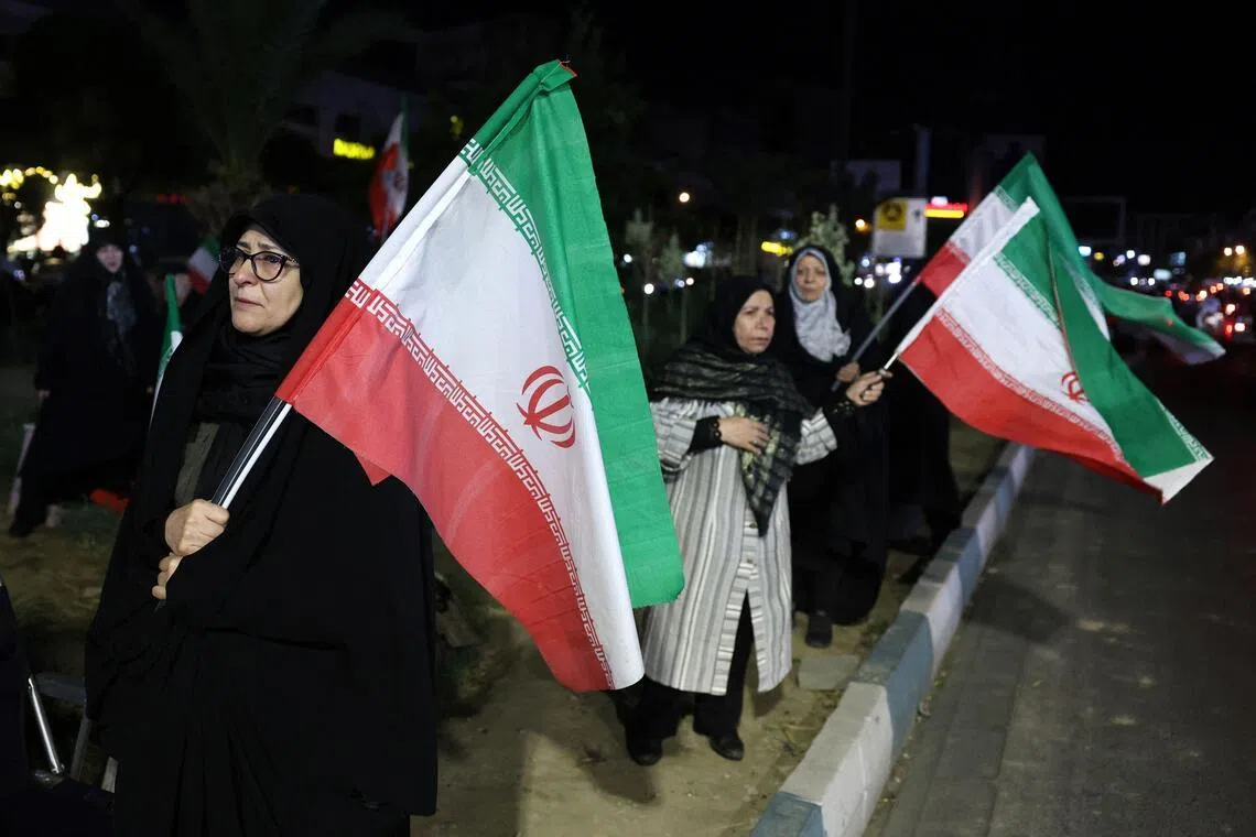 Women hold Iran's national flags during an anti-US and Israel protest in Tehran on May 17, 2026. 

