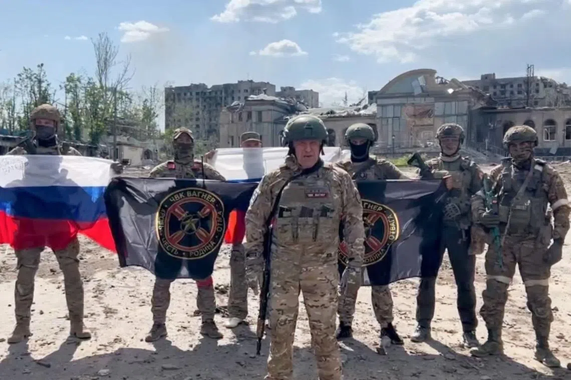 This video grab taken from a handout footage posted on May 20, 2023 on the Telegram account of the press service of Concord -- a company linked to the chief of Russian mercenary group Wagner, Yevgeny Prigozhin -- shows Yevgeny Prigozhin holding a Russian national flag in front of his soldiers holding Wagner Group's flags in Bakhmut, amid the Russian invasion of Ukraine. Russia's private army Wagner claimed on May 20, 2023, the total control of the east Ukrainian city of Bakhmut, the epicentre of fighting, as Kyiv said the battle was continuing but admitted the situation was "critical". Bakhmut, a salt mining town that once had a population of 70,000 people, has been the scene of the longest and bloodiest battle in Moscow's more than year-long Ukraine offensive. The fall to Russia of Bakhmut, where both Moscow and Kyiv are believed to have suffered huge losses, would have high symbolic value. (Photo by Handout / various sources / AFP) / RESTRICTED TO EDITORIAL USE - MANDATORY CREDIT "AFP PHOTO /  Telegram channel of Concord group" - NO MARKETING - NO ADVERTISING CAMPAIGNS - DISTRIBUTED AS A SERVICE TO CLIENTS