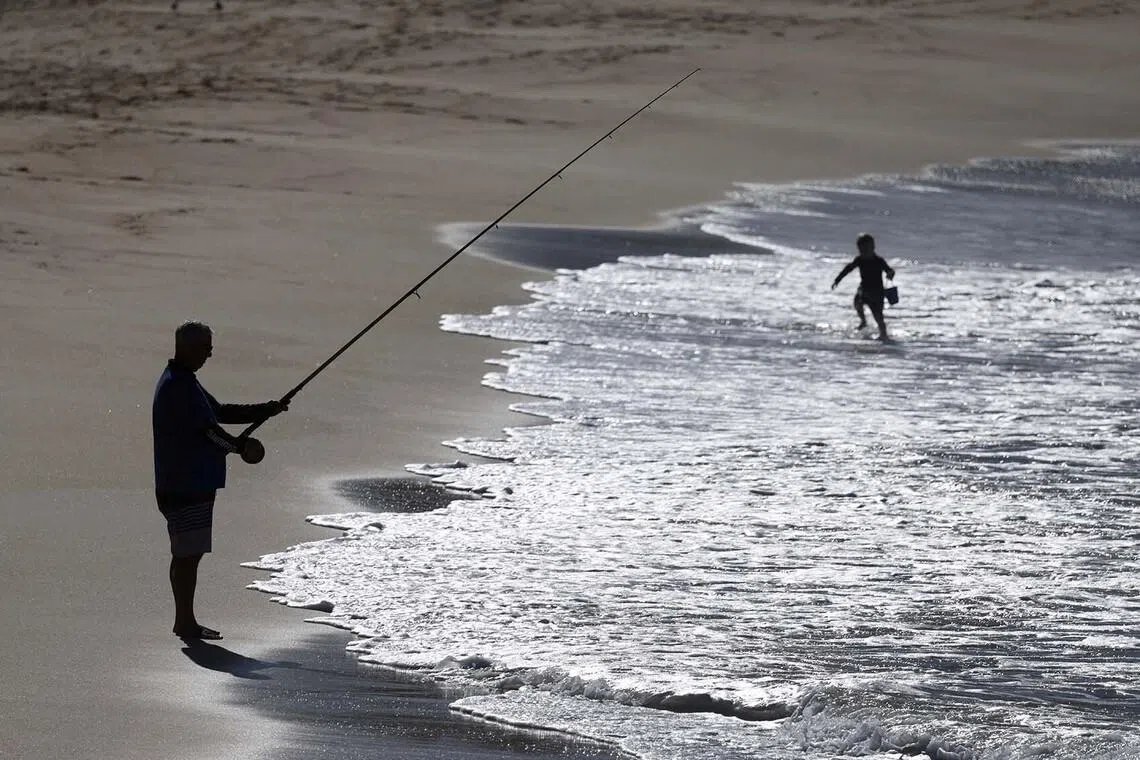 A man fishing off Coogee Beach following a shark attack on Saturday, in Sydney, Australia, June 16.