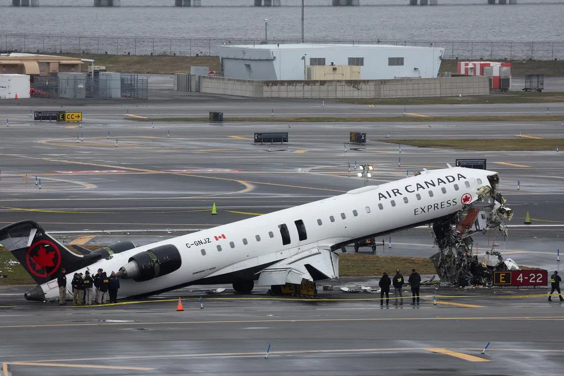 Personnel of the National Transportation Safety Board (NTSB) inspect the wreckage of an Air Canada Express jet that collided with a ground vehicle at New York's LaGuardia Airport in Queens, New York, U.S., March 23, 2026.  REUTERS/Shannon Stapleton