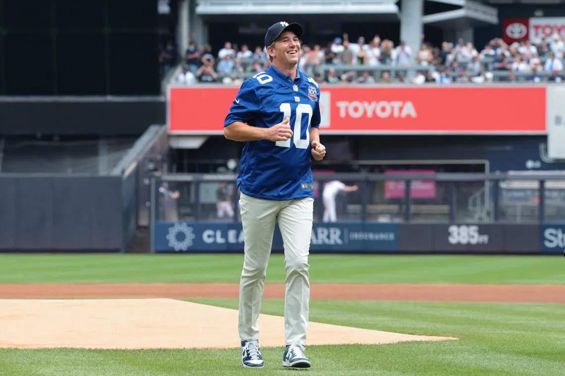Aug 4, 2024; Bronx, New York, USA; New York Giants former quarterback Eli Manning reacts after throwing the first pitch before the game between the New York Yankees and the Toronto Blue Jays at Yankee Stadium. Mandatory Credit: Vincent Carchietta-USA TODAY Sports