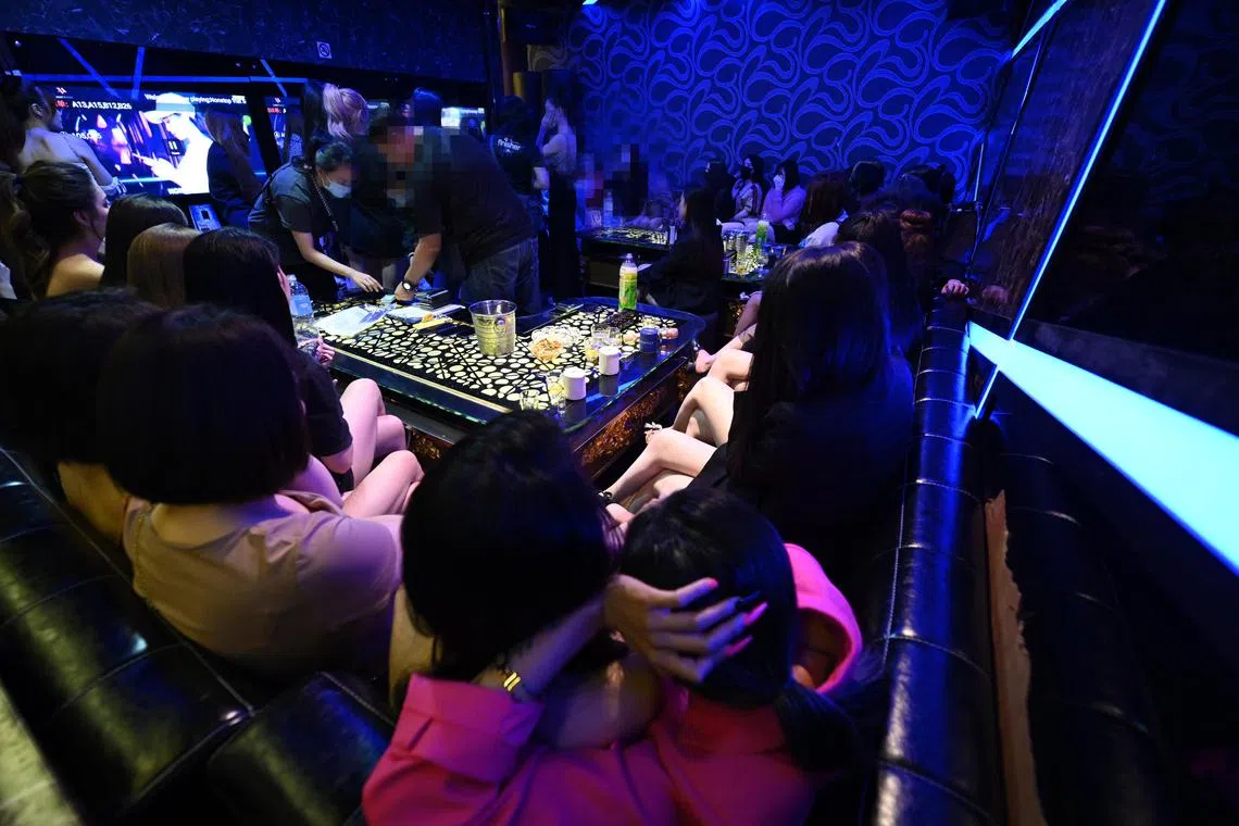 Police checking on the personal documents that belong to the suspected girls being detained inside a KTV in Textile Centre on 9 December 2022.