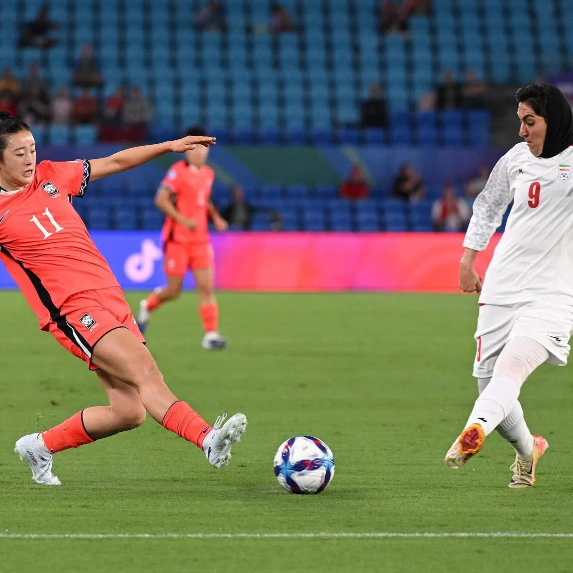 Choe Yu-ri of South Korea competes with Zahra Ghanbari of Iran during their Women's Asian Cup match.