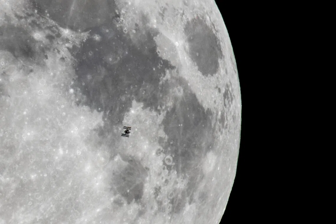 Nasa's International Space Station, orbiting the Earth, is captured against a backdrop of the Moon from Szurdokpuspoki, northern Hungary, on Nov 4, 2025.