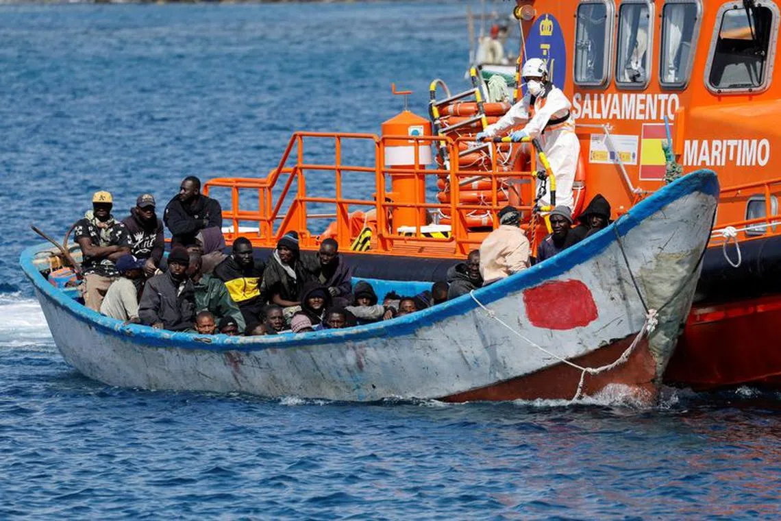 FILE PHOTO: Migrants wait to disembark from a fiber boat after being rescued by a Spanish coast guard vessel in the port of Arguineguin, Spain February 3, 2024. REUTERS/Borja Suarez/File Photo