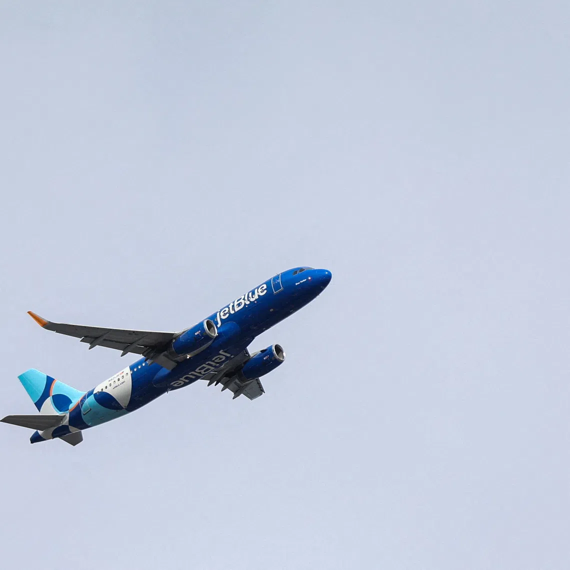 FILE: A JetBlue Airlines plane flies over the Queens borough of New York City, U.S., November 5, 2025. FILE/REUTERS/Kylie Cooper