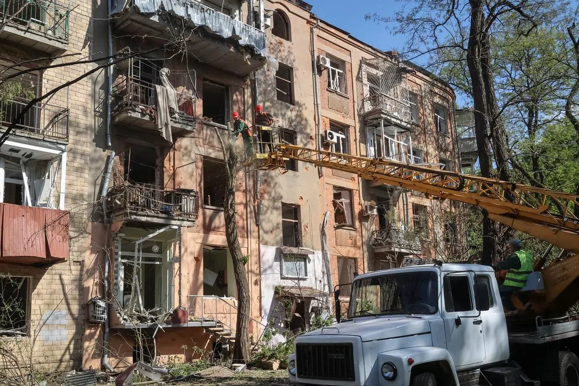 FILE PHOTO: Communal workers work at a site near an apartment building damaged by a Russian air strike, amid Russia's attack on Ukraine, in Kharkiv, Ukraine May 5, 2024. REUTERS/Vyacheslav Madiyevskyy/File Photo